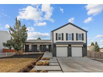 Charming two-story home featuring a three-car garage and modern, painted brick and siding exterior at 16402 E Tennessee Ave, Aurora, CO 80017