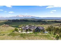 Expansive mountain home with lush green surroundings and a large driveway at 15295 E Cherry Creek S Rd, Larkspur, CO 80118