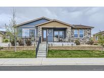 Charming single-Gathering home with stone accents, landscaped yard, and welcoming front porch at 12930 Bobcat Ct, Broomfield, CO 80021