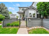 Charming home exterior with well-maintained lawn and decorative stone accents, enhanced by a stylish dark metal fence and gate at 3748 Oakwood Dr, Longmont, CO 80503