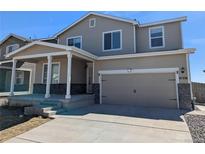 Charming two-story home with a covered porch, attached garage, and well-maintained lawn in a desirable neighborhood at 47356 Lilac Ave, Bennett, CO 80102