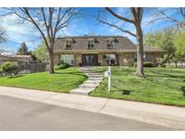 Charming brick home with mature trees, a well-manicured lawn, and inviting curb appeal in a quiet neighborhood at 6116 W Frost Dr, Littleton, CO 80128