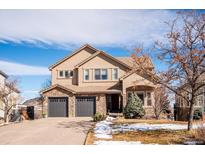 Charming two-story home with a three-car garage, stone accents, and a well-maintained front yard at 16403 River Haven Way, Morrison, CO 80465