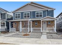 Charming two-story townhome with a stone facade and a small, well-maintained front yard at 22292 E 7Th Pl, Aurora, CO 80018