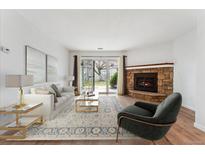 Bright living room features a stone fireplace, sliding glass doors, and modern decor at 3600 S Pierce St # 1-104, Lakewood, CO 80235