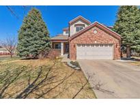 Charming brick two-story home with mature trees and attached two-car garage at 19823 E 58Th Ave, Aurora, CO 80019