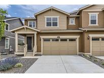 Inviting two-story home featuring a two-car garage, stone landscaping and cozy front porch at 8982 Spaulding St, Parker, CO 80134