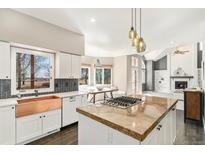 Bright, open kitchen boasts a copper sink, modern appliances, granite countertops and an island cooktop with pendant lights at 6406 Eagle Ct, Longmont, CO 80503