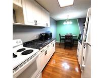 Bright eat-in kitchen with white cabinets and black countertops at 2375 S Linden Ct # 104, Denver, CO 80222