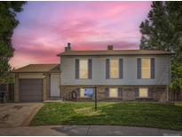 Charming two-story home with vinyl siding, brick accents, landscaped lawn, and an attached garage at 11062 Hudson Ct, Thornton, CO 80233