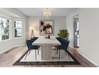 Elegant dining room with modern lighting, a stylish table set, and large windows for natural light at 8414 Bed Straw St, Parker, CO 80134