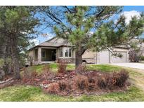 Beautiful ranch-style home with stone accents, attached garage, and well-manicured front yard with mature trees at 3228 Country Club Pkwy, Castle Rock, CO 80108