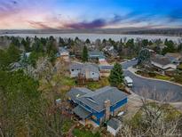 Stunning aerial view of a charming blue home near a tranquil lake, nestled in a lush, tree-filled neighborhood at 3053 Mcintosh Dr, Longmont, CO 80503