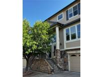 Beautiful home featuring a stone facade, well-maintained landscaping, and a welcoming entrance with a charming porch and detailed trim at 11328 W Radcliffe Dr, Littleton, CO 80127