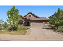 Charming single-Gathering home with a stone and brown siding, a well-manicured front yard, and an attached two-car garage at 5437 S Granby Ct, Aurora, CO 80015