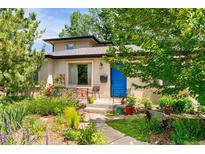Charming home featuring a blue front door, manicured landscaping, and a welcoming front porch at 4590 Grove St, Denver, CO 80211