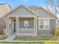 Charming home featuring a covered front porch, two stories, a manicured lawn, and stylish curb appeal at 9626 E 105Th Pl, Commerce City, CO 80640