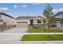 Charming one-story home with a well-manicured lawn, stone accents, and an attached two-car garage at 24780 E 39Th Ave, Aurora, CO 80019