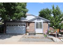 Charming two-story home featuring a brick facade, well-maintained landscaping, and an attached two-car garage at 7988 S Johnson Ct, Littleton, CO 80128