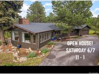 Charming single-Gathering home featuring mature trees, manicured landscaping, and an 'Open House' banner at 29663 Paint Brush Dr, Evergreen, CO 80439