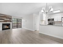 Open-concept living area featuring a fireplace, sliding glass doors, and updated kitchen with granite countertops at 14720 E Kentucky Dr # 622, Aurora, CO 80012