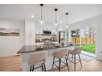 Bright kitchen features stainless appliances, sleek countertops, and a large island with bar seating at 5242 Columbine Ln, Denver, CO 80221