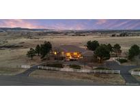 Charming home featuring a white fence, a circular driveway, and picturesque views of mountains in the background at 5540 Horseshoe Trl, Sedalia, CO 80135