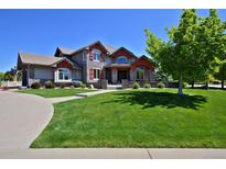 Charming two-story home featuring a lush, green lawn and manicured landscaping at 1315 W 141St Cir, Westminster, CO 80023