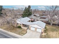 Aerial view of a brick home with a white roof and attached two-car garage on a tree-lined street at 2300 Joliet St, Aurora, CO 80010