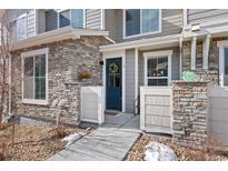 This is an exterior view of the townhome featuring stone and gray wood accents at 23539 E Ida Dr # C, Aurora, CO 80016