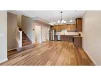 Open kitchen and living area with stainless steel appliances and wood plank flooring throughout at 23539 E Ida Dr # C, Aurora, CO 80016
