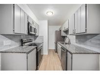 Modern kitchen featuring stainless steel appliances, grey cabinets, and granite countertops at 16259 W 10Th Ave # K-3, Golden, CO 80401