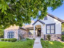 Charming front exterior with a stone and stucco facade, inviting porch, and well-manicured lawn at 1020 S Ammons Cir, Lakewood, CO 80226