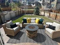 Cozy backyard featuring a stone fire pit, comfortable seating, and a well-maintained lawn at 3173 Youngheart Way, Castle Rock, CO 80109
