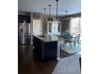Kitchen featuring an island and stainless steel appliances with open access to dining area at 3173 Youngheart Way, Castle Rock, CO 80109