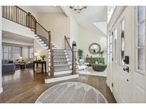 Inviting entryway with soaring ceilings, staircase, and elegant decor, creating a warm welcome to this beautiful home at 11623 E Ida Ave, Englewood, CO 80111