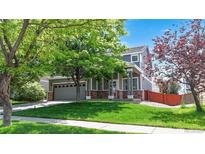 Charming two-story home with a well-manicured lawn, mature tree, and inviting front porch at 19730 E 58Th Pl, Aurora, CO 80019