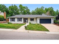 Charming home featuring a well-manicured lawn, painted brick and stone details and an attached two car garage at 6874 S Detroit Cir, Centennial, CO 80122