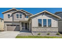 Charming two-story home featuring a stone facade, inviting entrance, and attached two car garage at 4599 Windmill Dr, Brighton, CO 80601