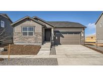 Charming single-Gathering home featuring stone accents and a two-car garage and a well-manicured lawn at 3911 N Shawnee St, Aurora, CO 80019