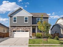 Charming two-story home featuring stone accents, gray siding, manicured lawn, and a two-car garage at 1181 W 170 Th Ave, Broomfield, CO 80023