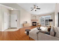 Inviting living room boasts a cozy fireplace, modern ceiling fan, and access to outdoor balcony at 7440 S Blackhawk St # 7-303, Englewood, CO 80112