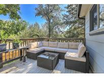 Inviting outdoor seating area on a wooden deck, perfect for relaxing and entertaining with surrounding trees at 16193 E Dickenson Pl, Aurora, CO 80013