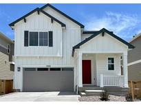 Charming two-story home with a red door, gray garage door, and a well-manicured lawn at 9286 Telluride Ct, Commerce City, CO 80022
