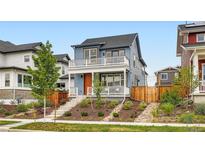 Charming two-story home boasts a welcoming porch, balcony, and well-manicured front yard at 9769 E 62Nd Dr, Denver, CO 80238