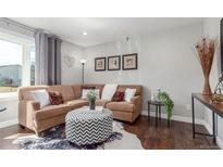 Inviting living room featuring a comfortable sofa, stylish ottoman, and a large window for natural light at 3541 E 118Th Ave, Thornton, CO 80233