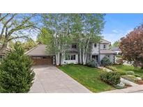 Inviting two-story home featuring a tile roof, lush lawn, and mature trees offering shade and curb appeal at 172 S Forest St, Denver, CO 80246