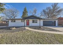 Charming updated home featuring a bright red door, fresh white paint, and an attached garage at 8340 W 70Th Ave, Arvada, CO 80004