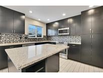 Modern kitchen with granite island, stainless steel appliances, and dark cabinetry at 12644 W Virginia Ave, Lakewood, CO 80228