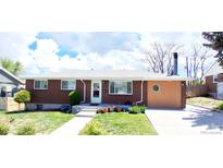 Charming brick home featuring a well-maintained front yard and driveway at 8338 Charles Way, Denver, CO 80221